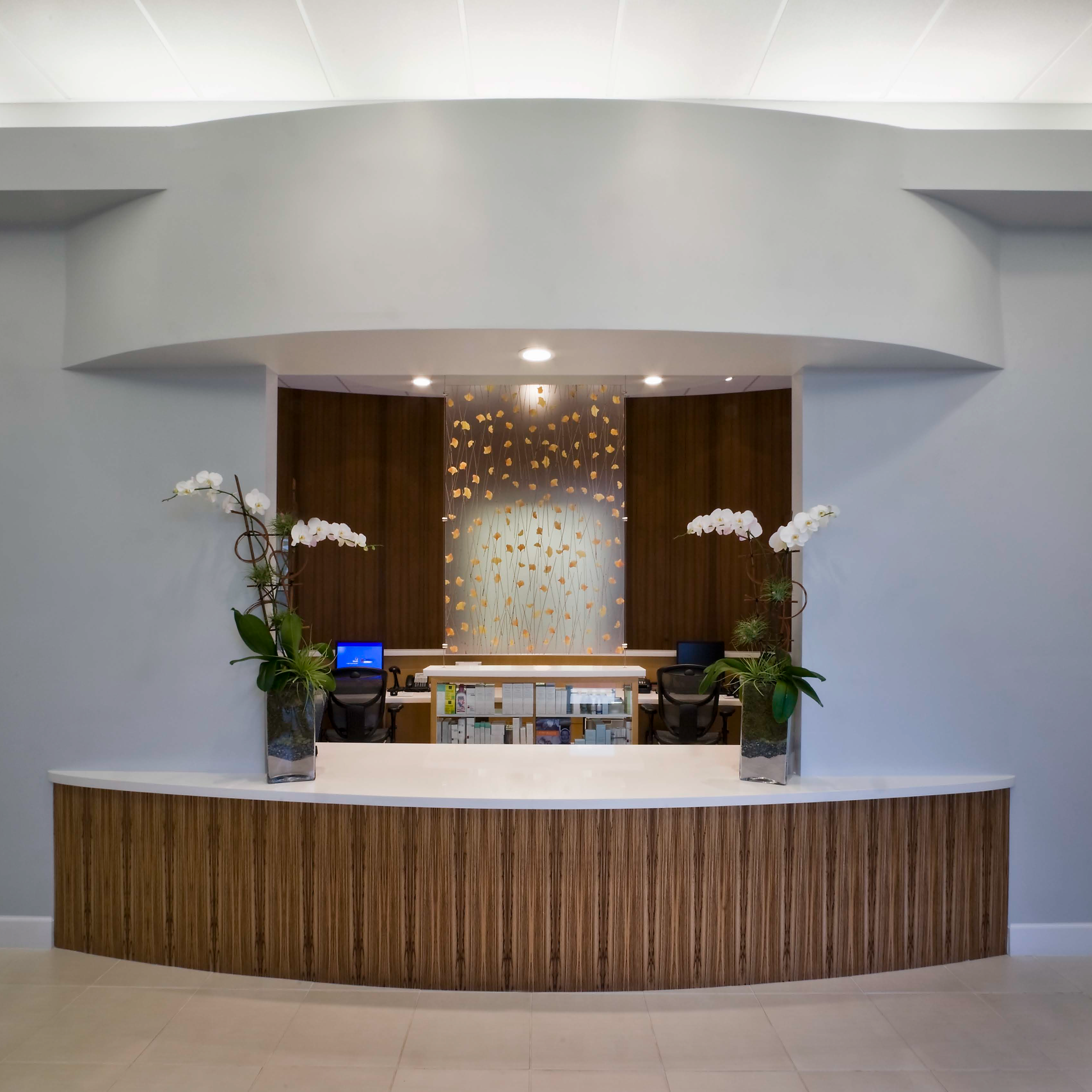 Bay Pointe Dermatology waiting room with a curved desk and decorative elements.